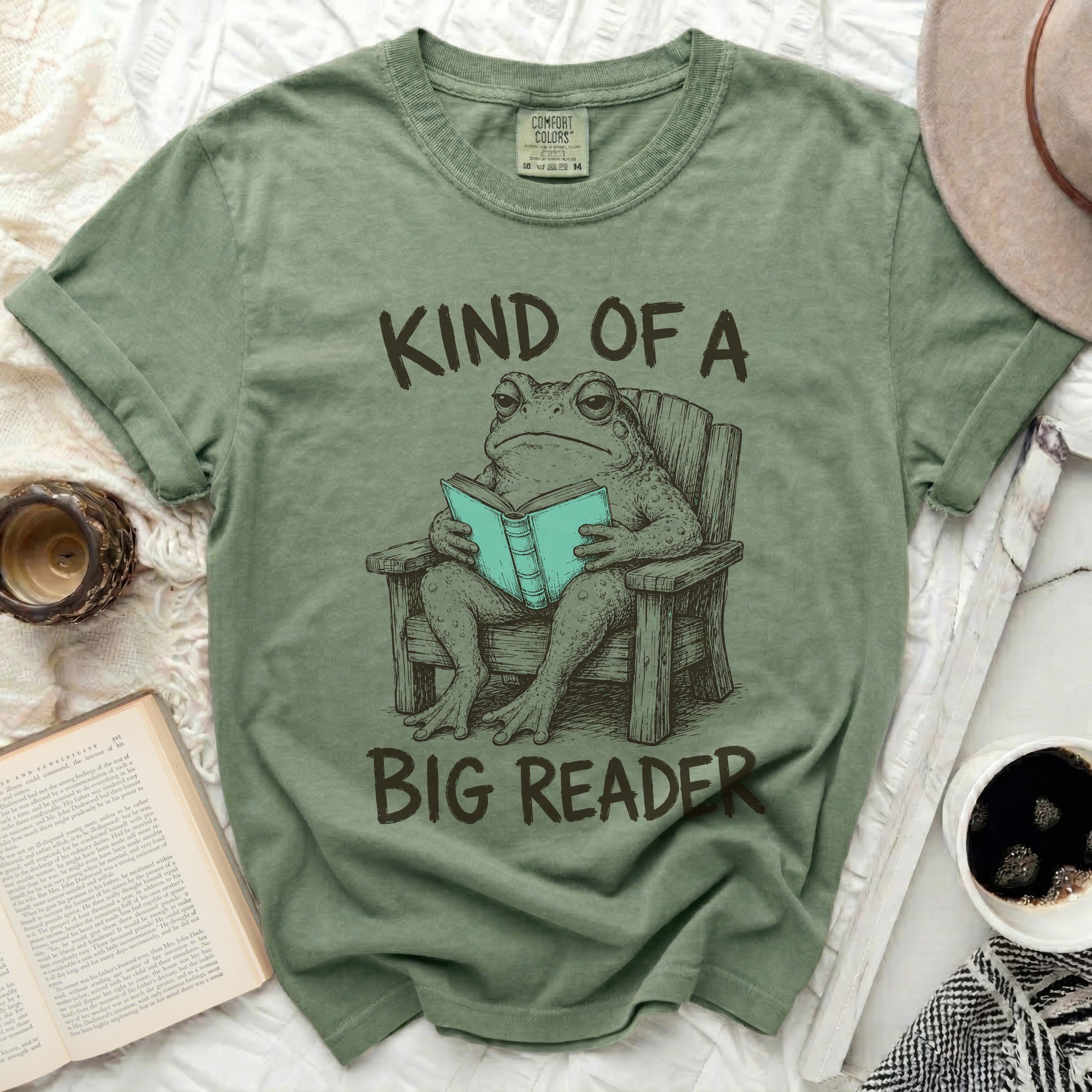 Green t-shirt with a frog reading a book and text 