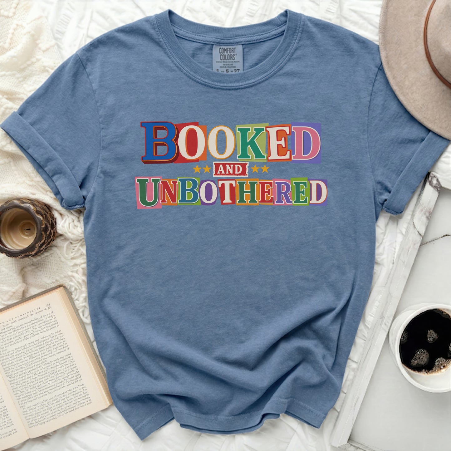 Comfort Colors shirt with "BOOKED AND UNBOTHERED" graphic.
