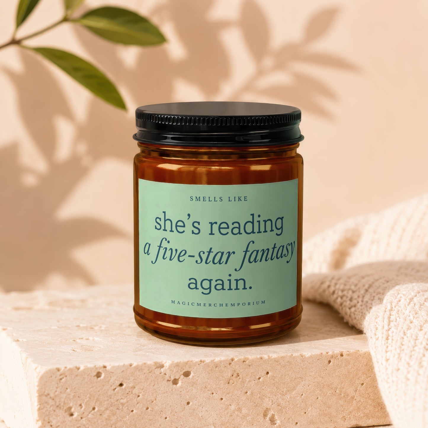 Candle with "She's reading a five-star fantasy again" text.