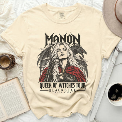 Cream t-shirt with "Manon Queen of Witches Tour" graphic featuring a woman and dragon.