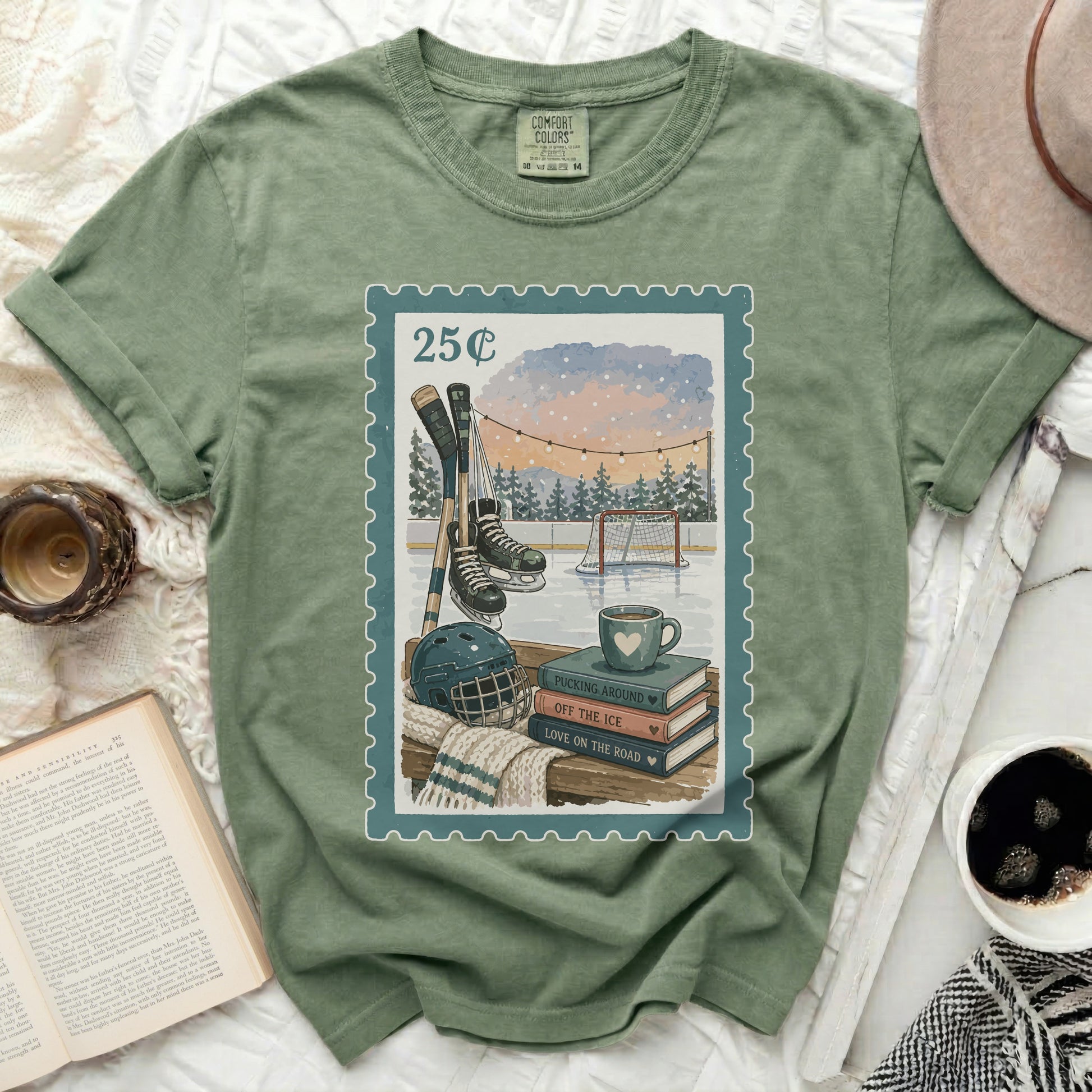 Green t-shirt with postage stamp graphic of hockey scene, books, and coffee.