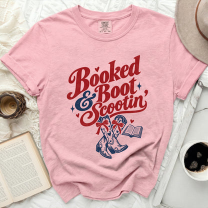 Pink t-shirt with "Booked & Boot Scootin'" text, cowboy boots, and an open book.