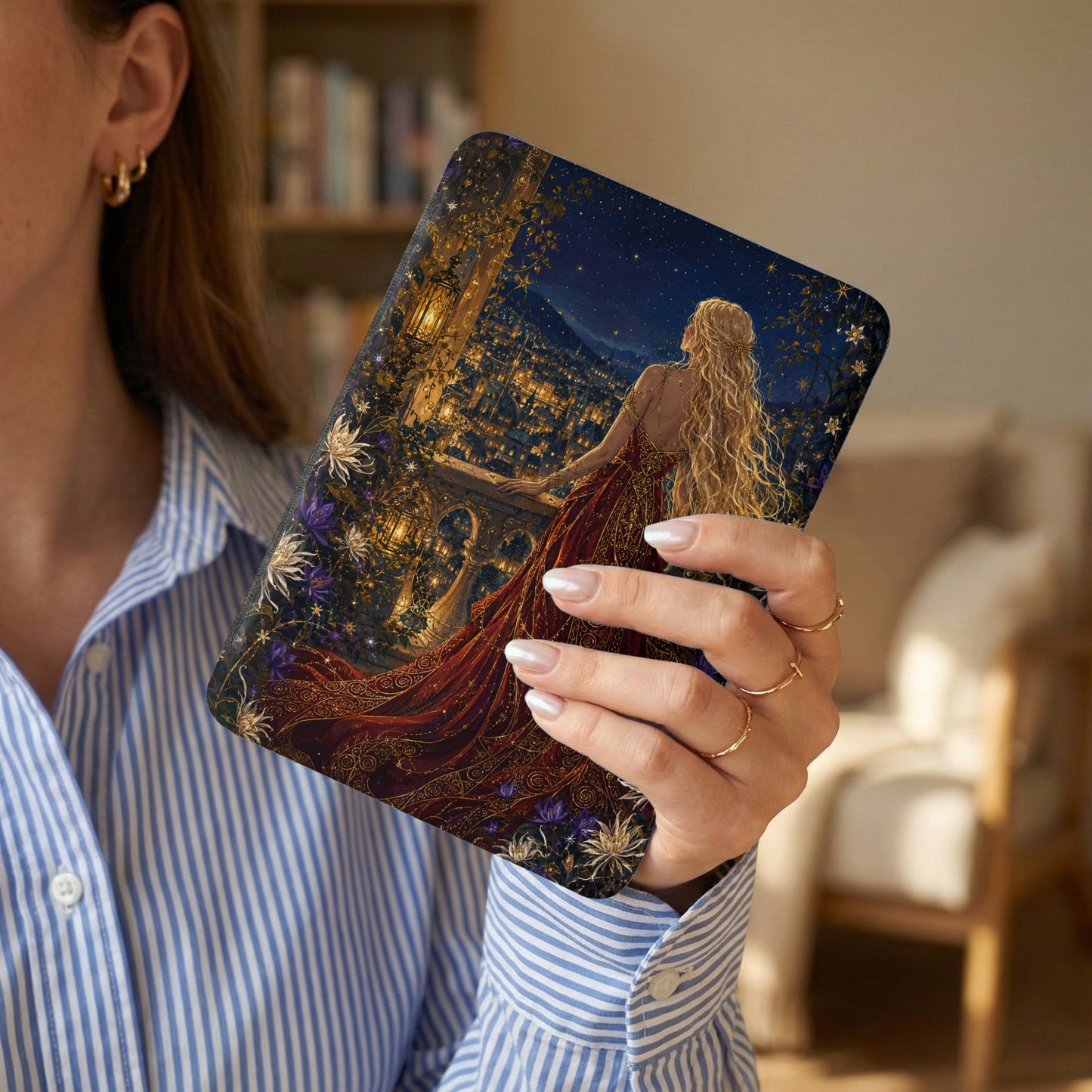 A woman holds a book with a starry night city scene and a woman in a red dress.