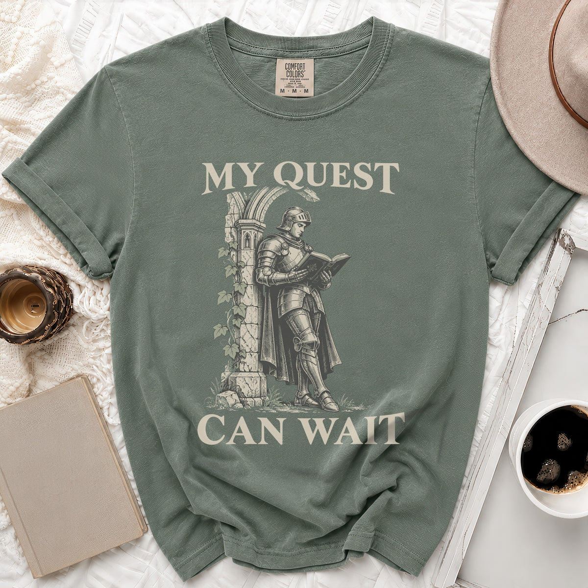 Green t-shirt with "My Quest Can Wait" and knight reading graphic.