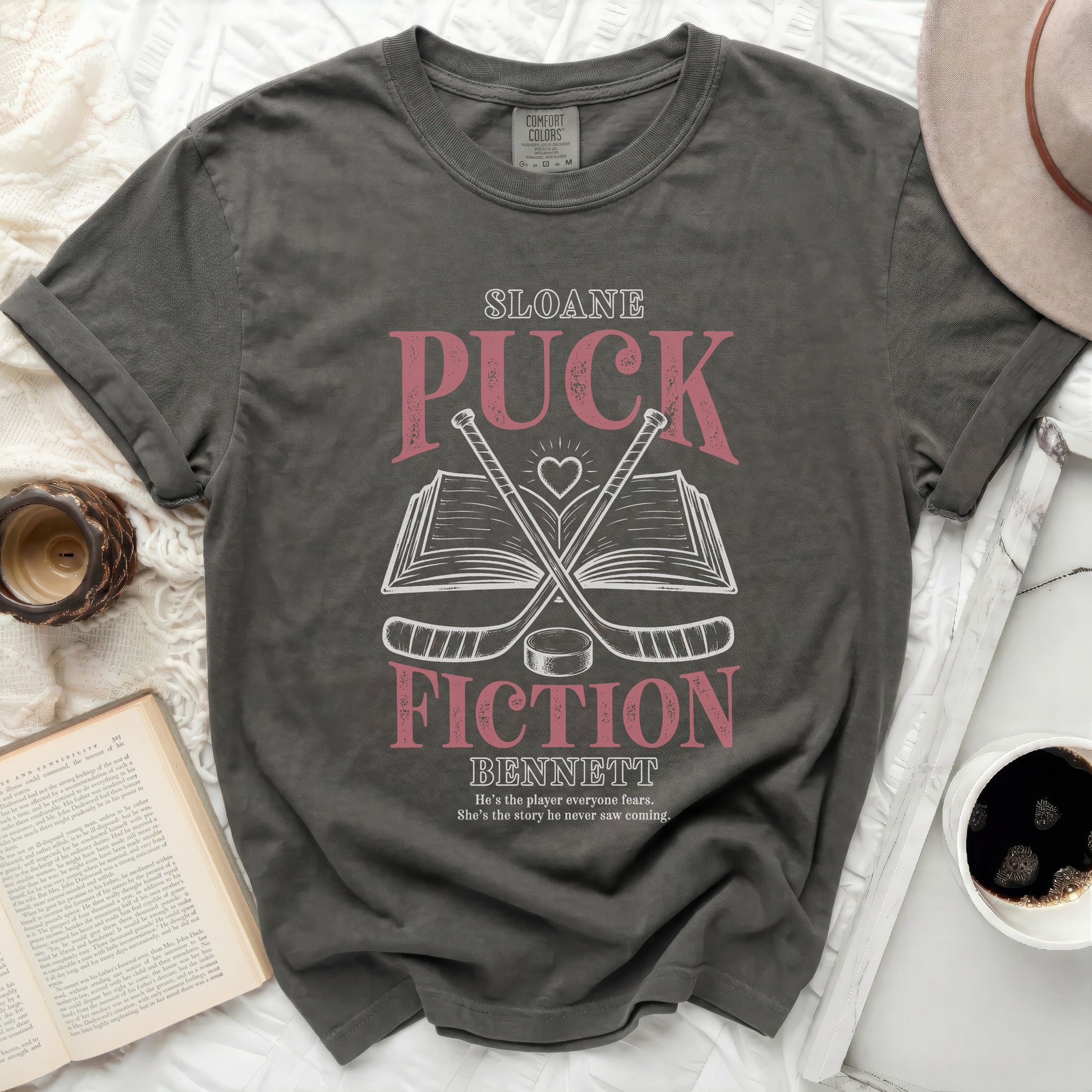 Dark grey t-shirt with "Sloane Fiction Bennett" title and hockey sticks.