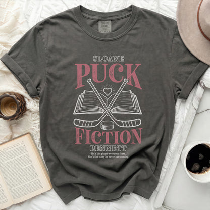 Dark grey t-shirt with "Sloane Fiction Bennett" title and hockey sticks.