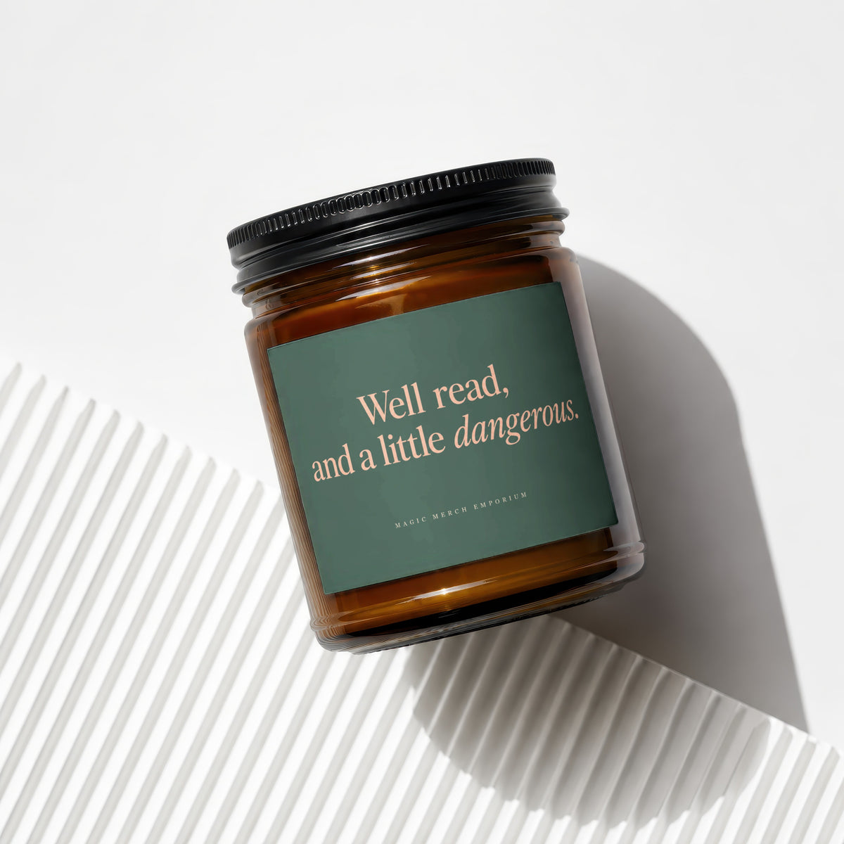 Amber candle with dark green label reading "Well read, and a little dangerous."