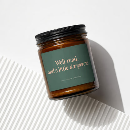 Amber candle with dark green label reading "Well read, and a little dangerous."