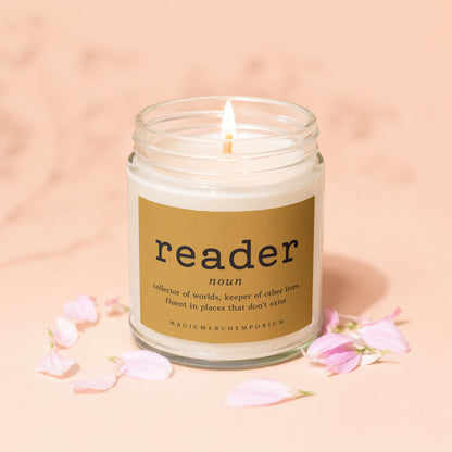 Glass candle with "reader" definition label and lit wick.