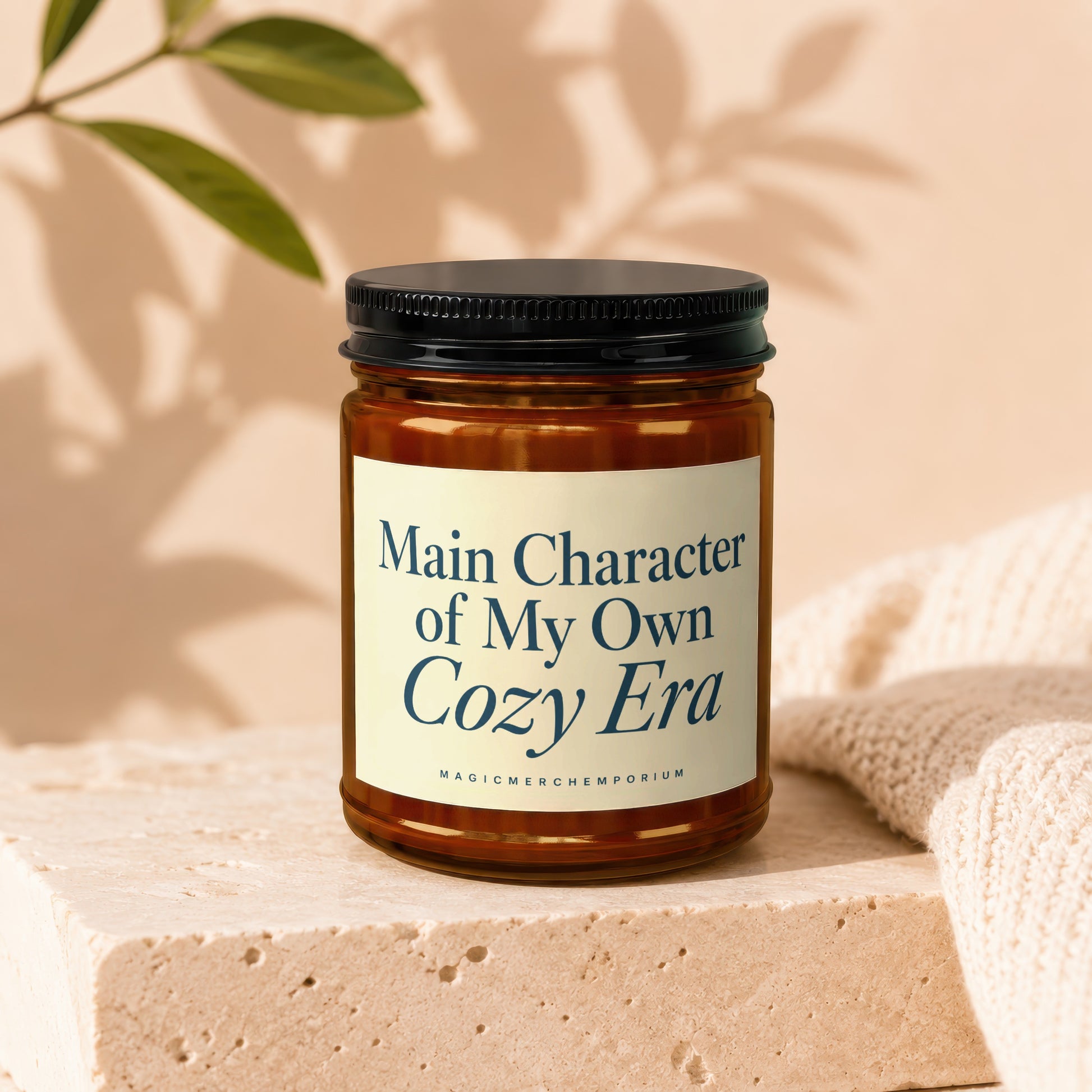 Candle with text "Main Character of My Own Cozy Era" on cream label.