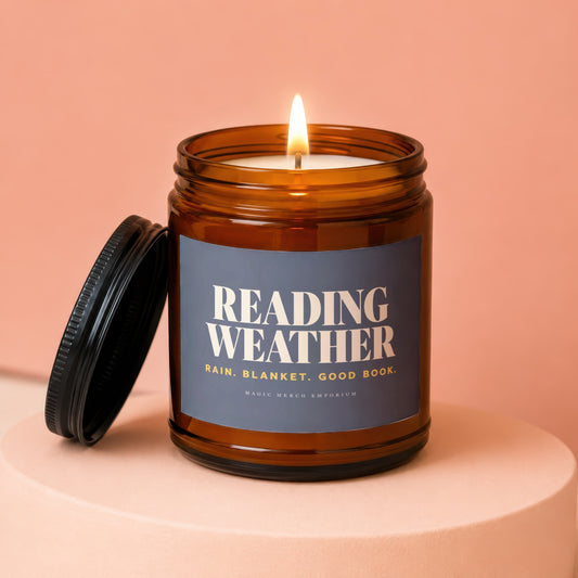 Amber candle jar with lit flame, label reads "Reading Weather".