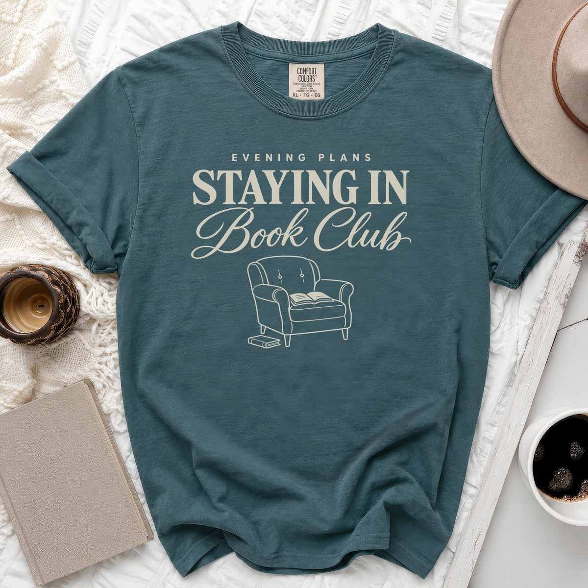 Teal t-shirt with "Evening Plans Staying In Book Club" text and graphic.
