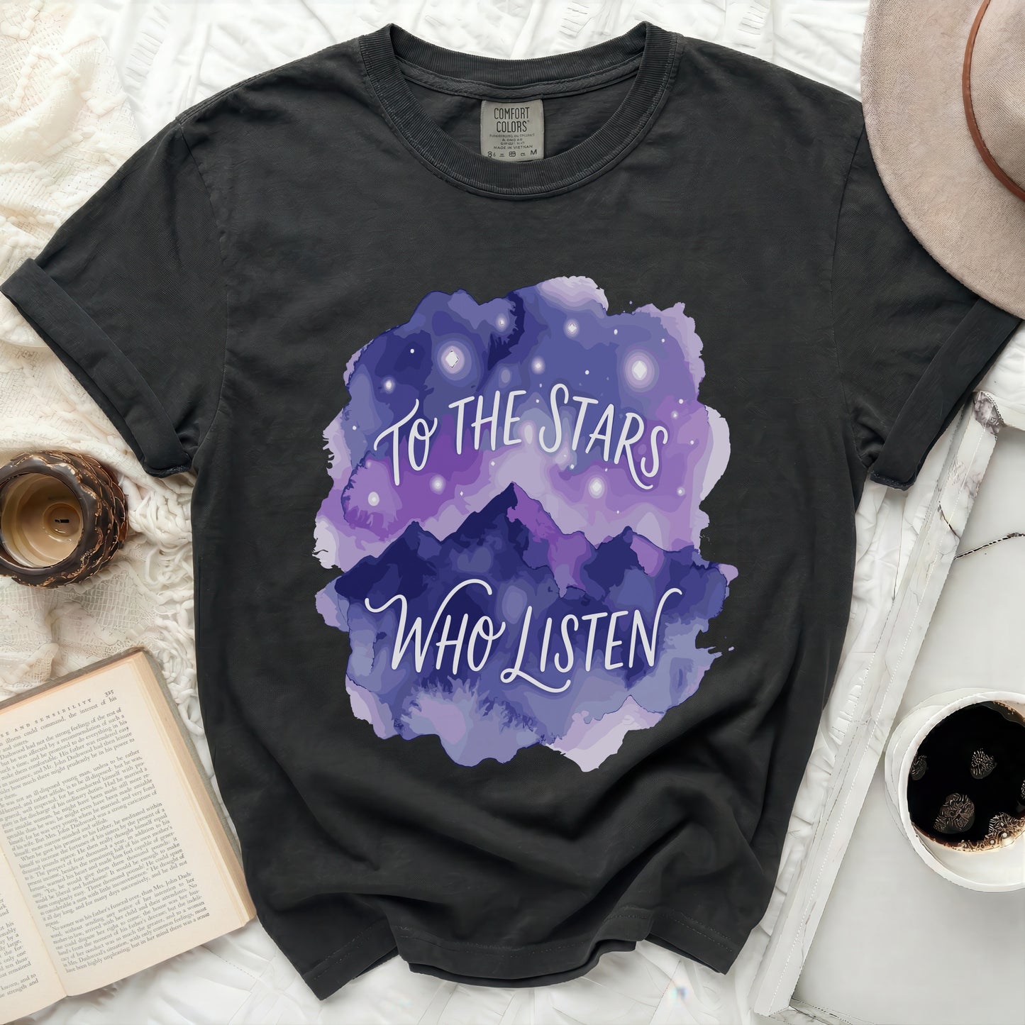 Dark t-shirt with purple watercolor mountains and "To the Stars Who Listen" text.