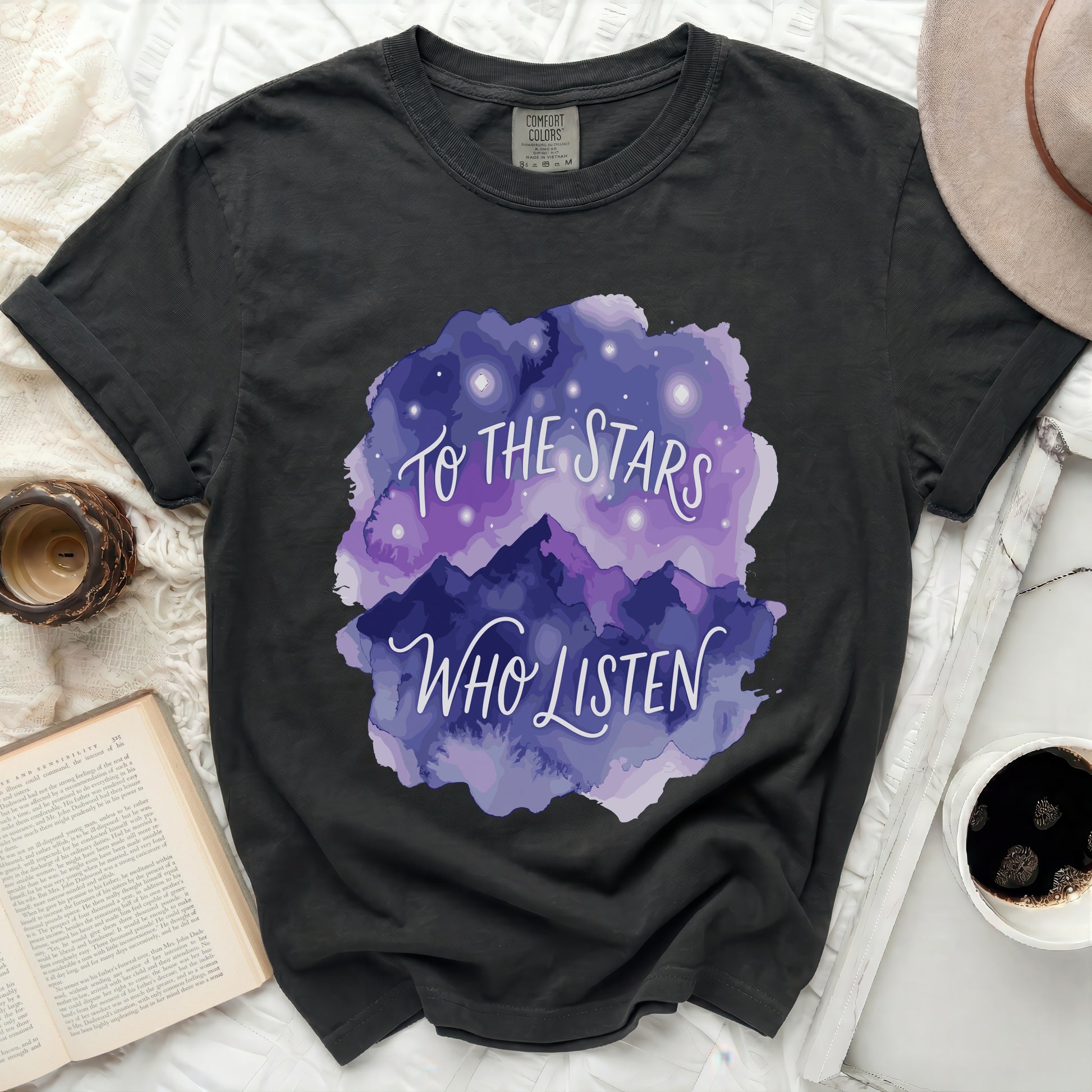 Dark t-shirt with purple watercolor mountains and "To the Stars Who Listen" text.