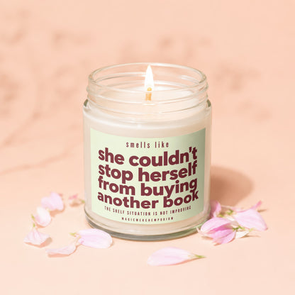 Glass candle with label reading "smells like she couldn't stop herself from buying another book".