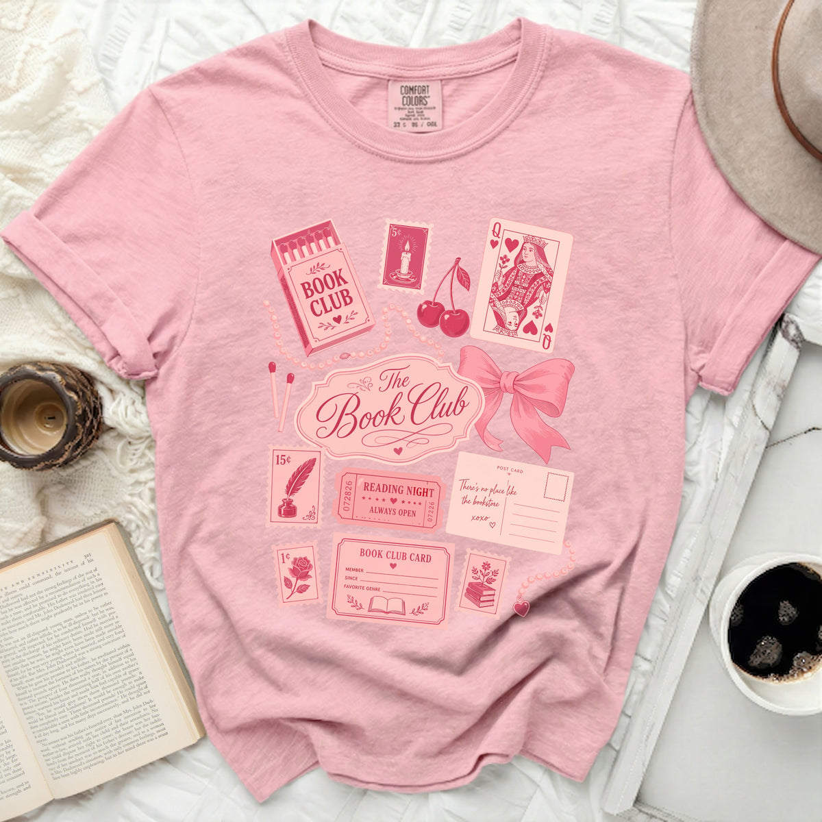 Pink t-shirt with "The Book Club" graphic and vintage book-themed illustrations.