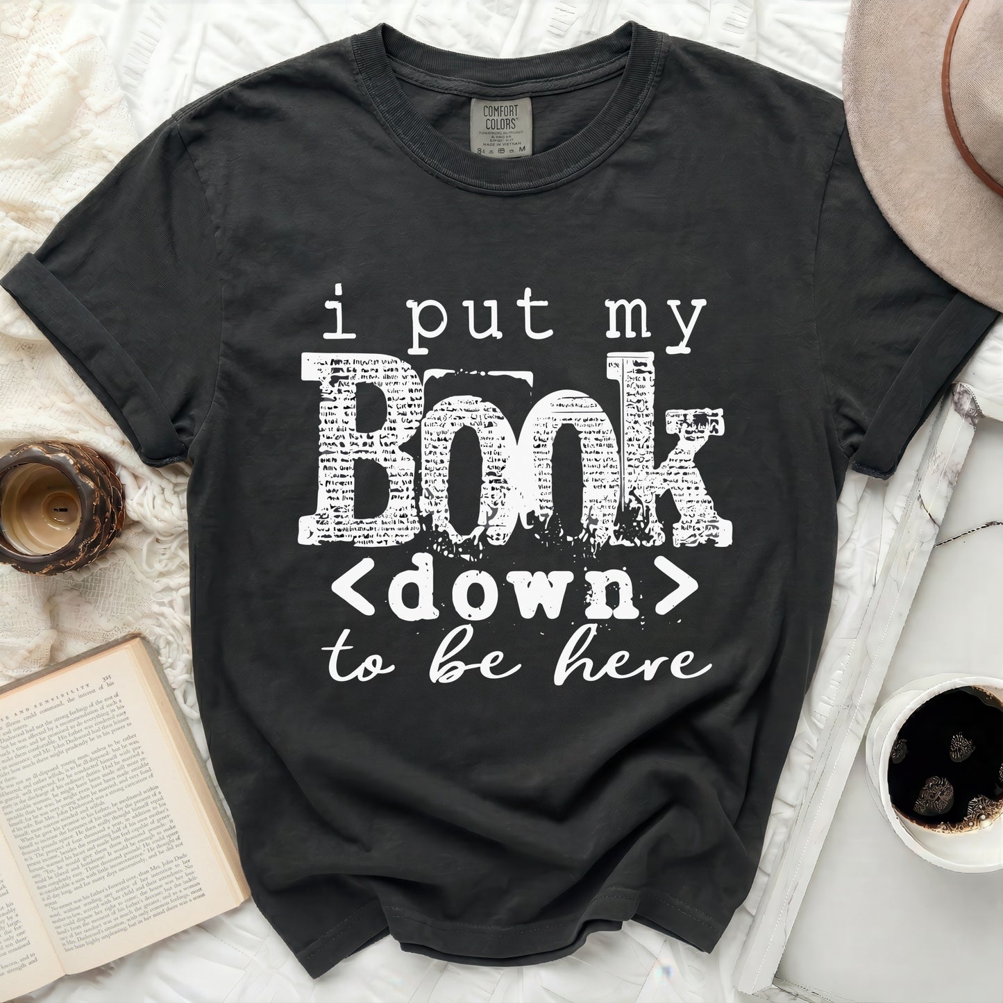 Dark gray t-shirt with white text "i put my Book <down> to be here".