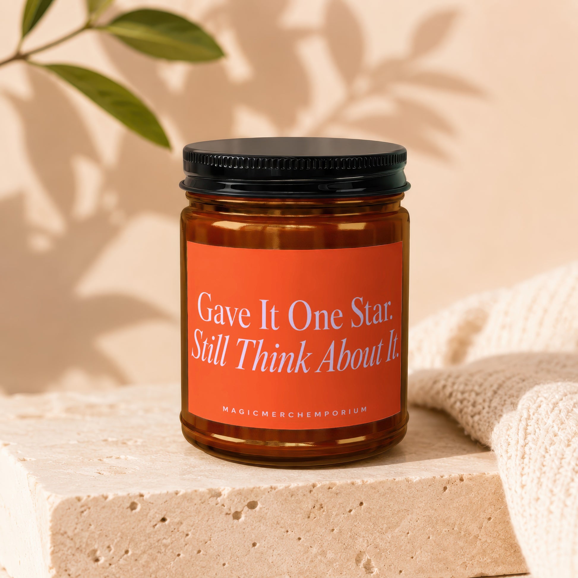 Amber jar candle with orange label reading "Gave It One Star. Still Think About It."