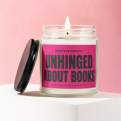 Lit jar candle with pink label: "PROFESSIONALLY UNHINGED ABOUT BOOKS" and "MAGICMERCHEMPORIUM"