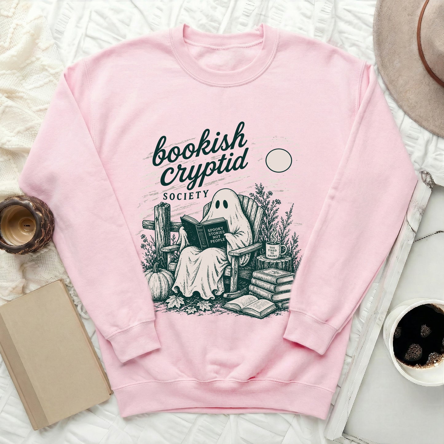 Pink sweatshirt with ghost reading "Spooky Stories Not People" and "Bookish Cryptid Society" text.
