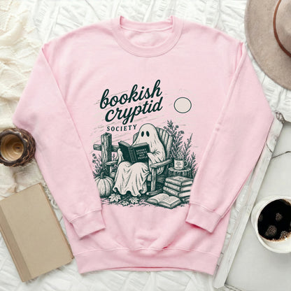 Pink sweatshirt with ghost reading "Spooky Stories Not People" and "Bookish Cryptid Society" text.