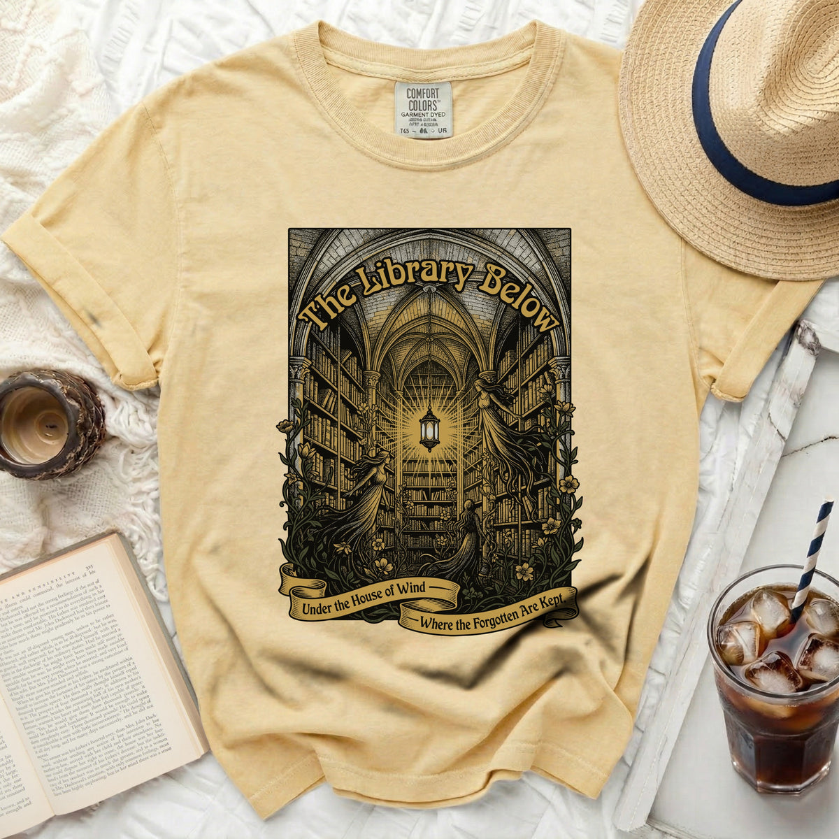Yellow t-shirt with "The Library Below" and winding banner text.