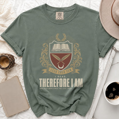 Green t-shirt with an emblem featuring an open book, quills, and the text "LEGO ERGO SUM I READ, THEREFORE I AM".