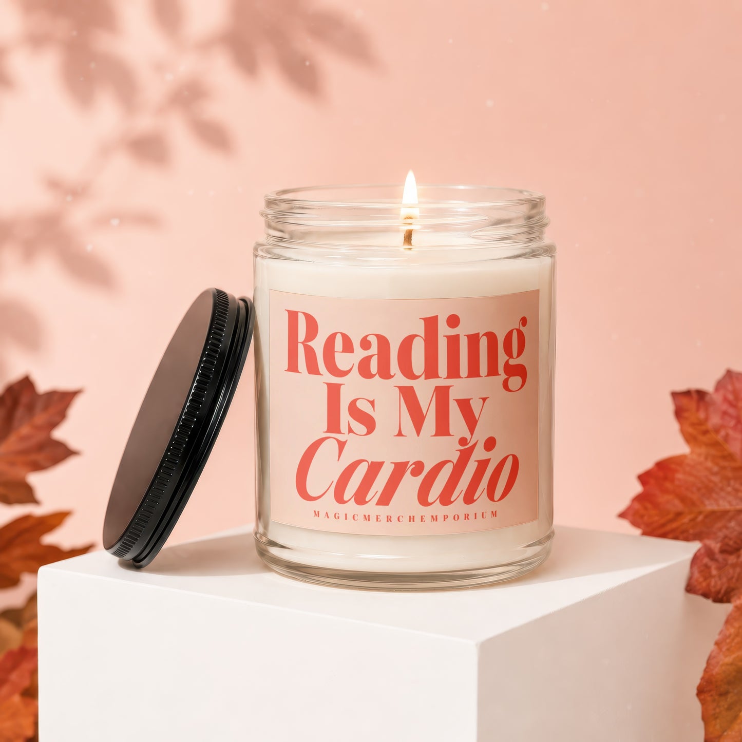 Glass candle with lid removed, "Reading Is My Cardio" text, and autumn leaves.