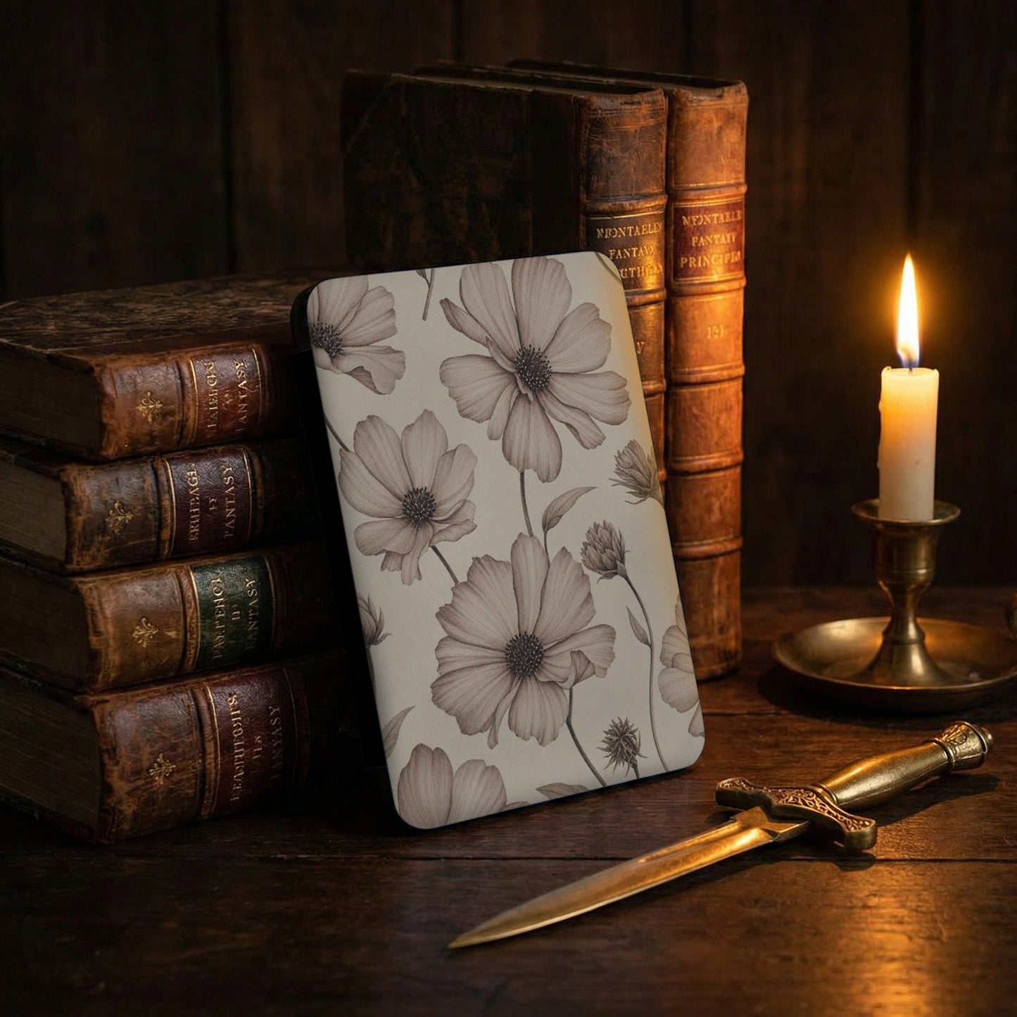 Leather-bound books with "Fantasy" titles beside a floral-patterned object and candle.