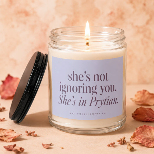 Lit candle in a glass jar with a label reading, she's not ignoring you. She's in Prytian.