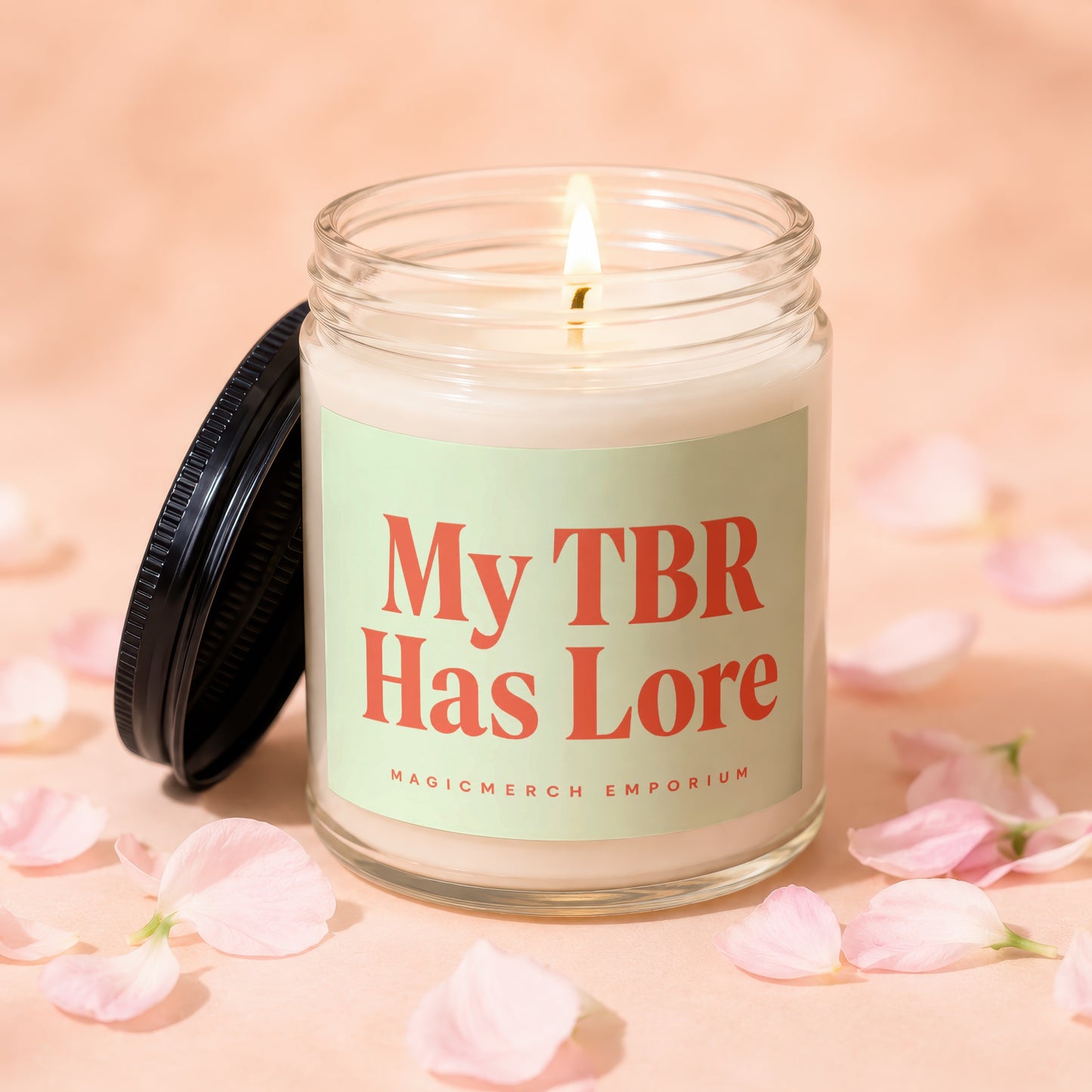 Candle inscribed with "My TBR Has Lore" surrounded by pink petals