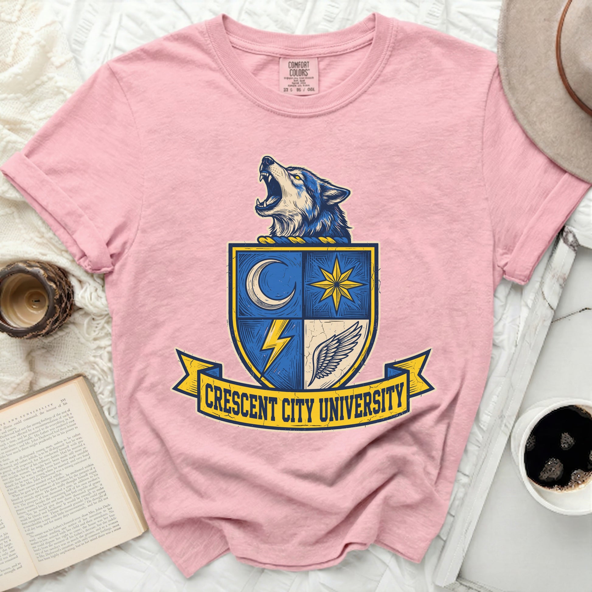 Pink t-shirt with a crest featuring a howling wolf and "Crescent City University".
