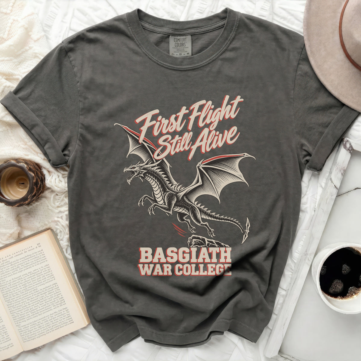 Gray t-shirt with a dragon graphic and text "First Flight Still Alive Basgiath War College".