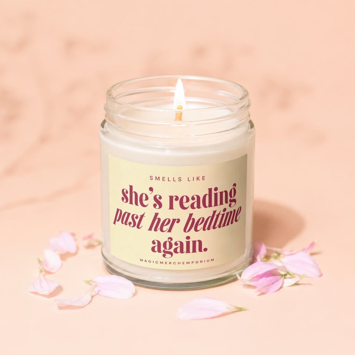 Candle with text "she's reading past her bedtime again." surrounded by petals.
