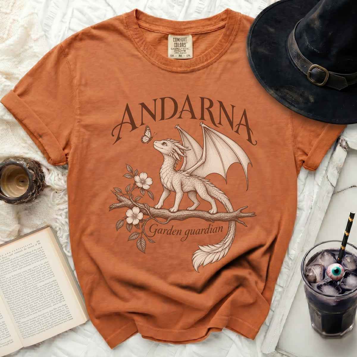 Orange t-shirt with a dragon, butterfly, flowers, and text "ANDARNA Garden guardian".