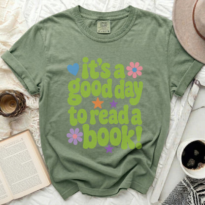 Green t-shirt with "it's a good day to read a book!" text and floral graphics.