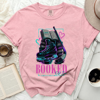Pink t-shirt with "Booked Off Ice" graphic of books, skates, and hockey stick.