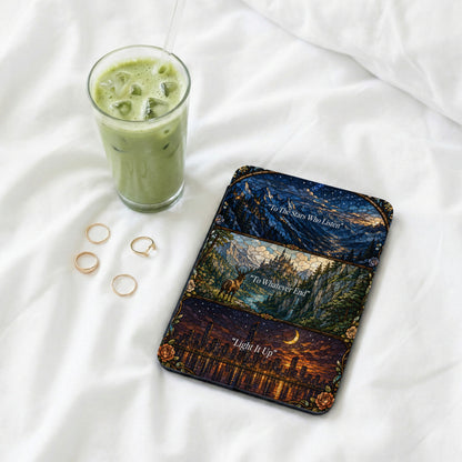 Phone case with mosaic art of night sky, castle, and city, beside iced green drink.
