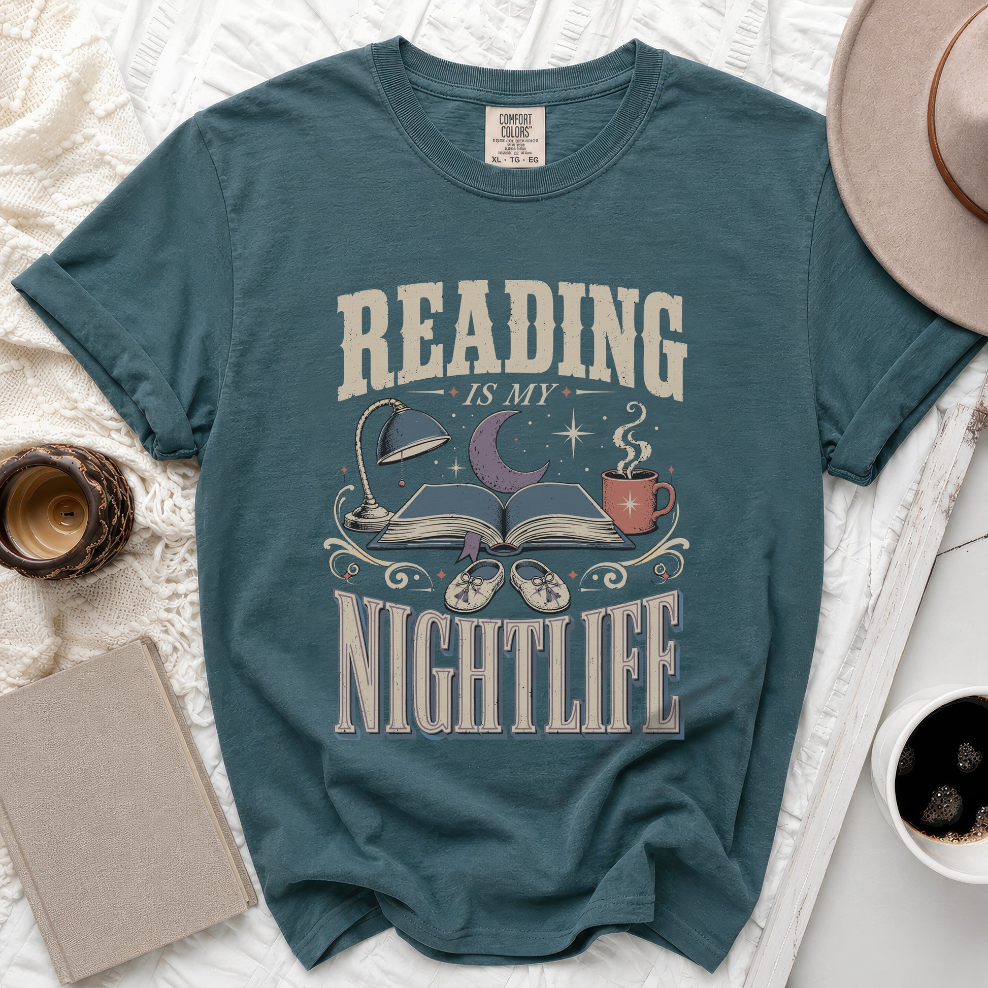 Teal t-shirt with "READING IS MY NIGHTLIFE" graphic featuring books, moon, and coffee cup.