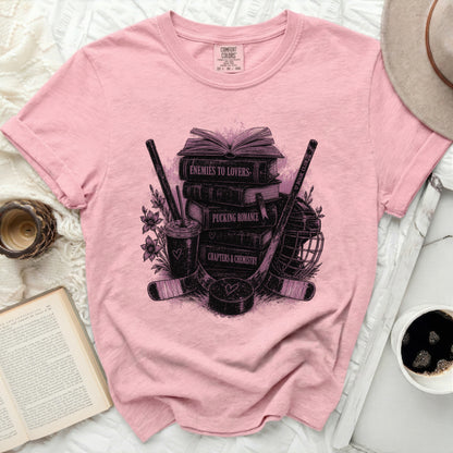 Pink t-shirt with books, hockey sticks, and "Pucking Romance" text.