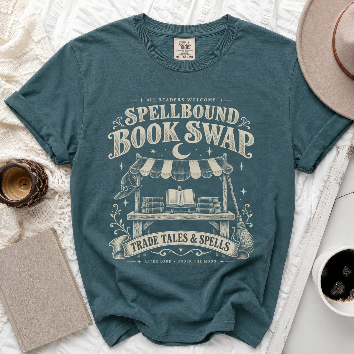 Teal t-shirt with "Spellbound Book Swap" and "Trade Tales & Spells" text.