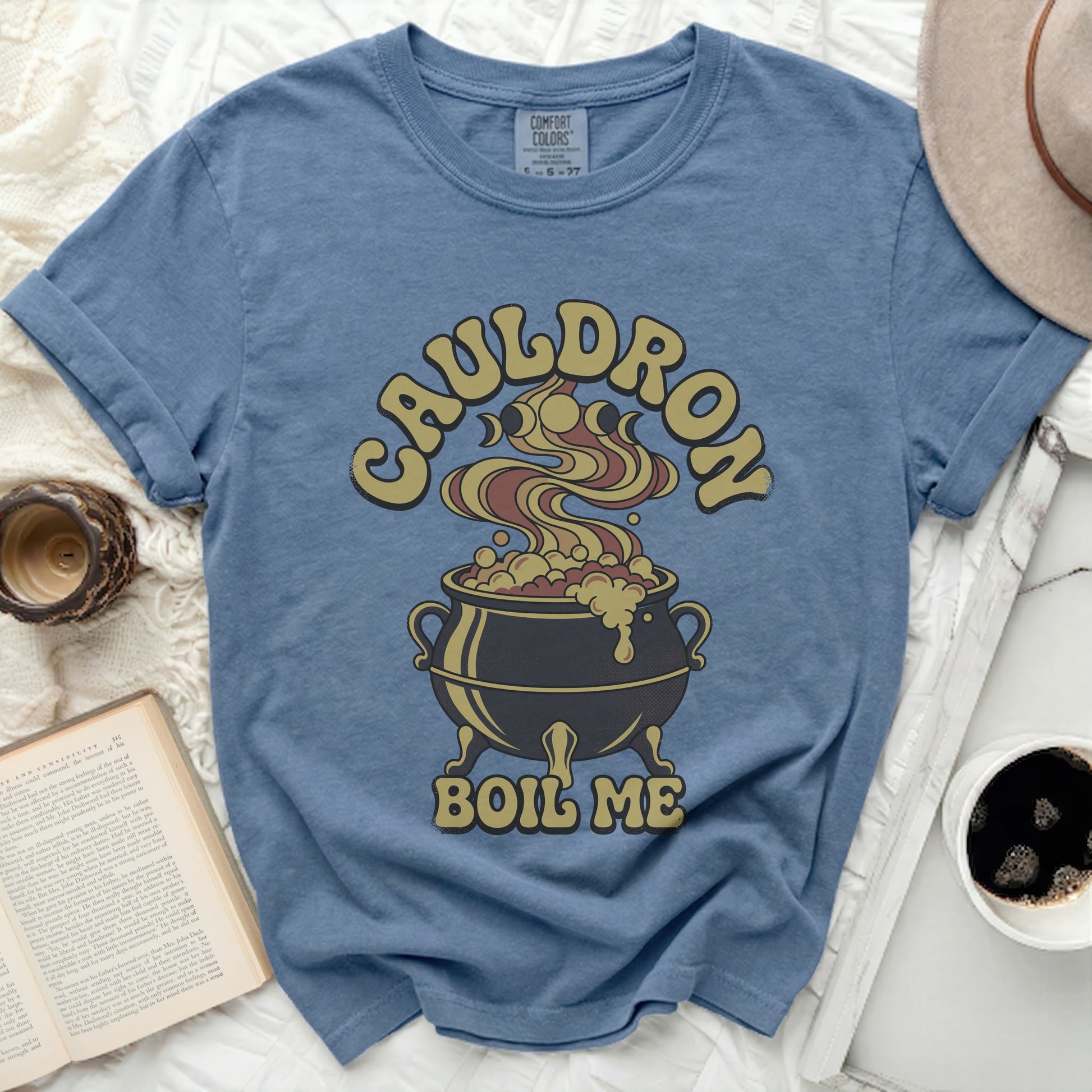 Blue t-shirt with a cauldron graphic and text that reads "CAULDRON BOIL ME".