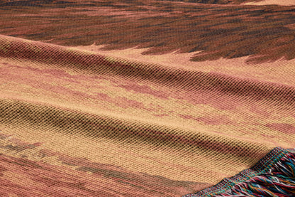a close-up view of a woven fabric with a textured pattern, featuring a mix of warm colors such as brown, orange, and beige.