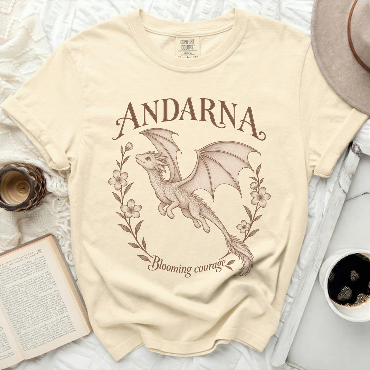 Cream t-shirt with "ANDARNA Blooming courage" and a dragon graphic.