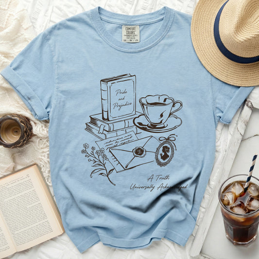 Light blue t-shirt with line art of books, teacup, envelope, and locket.