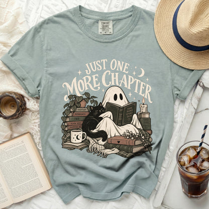 T-shirt graphic of ghost reading with cat and books, text "Just One More Chapter".