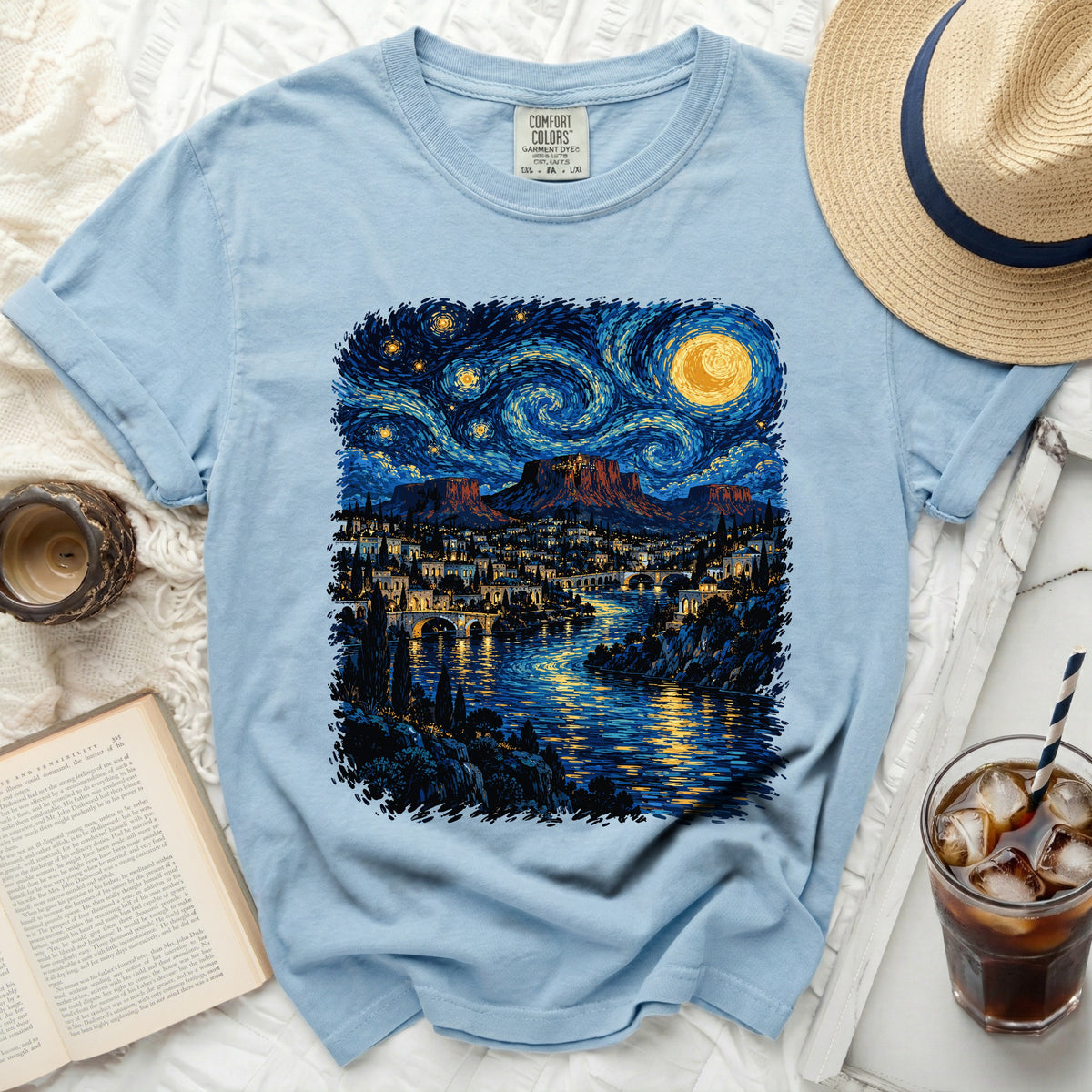 Light blue t-shirt with a starry night landscape print.