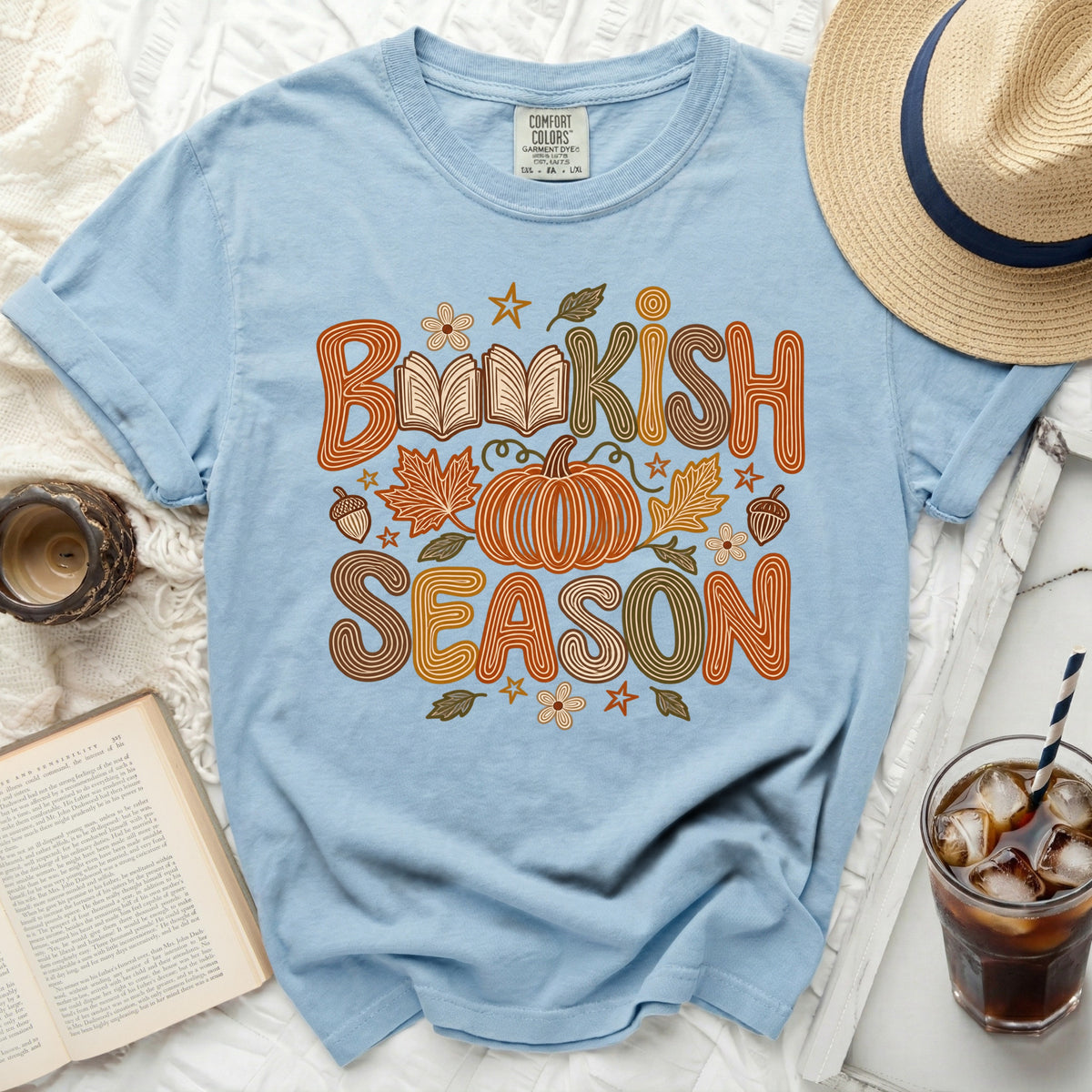 Light blue t-shirt with "Bookish Season" text, pumpkin, and autumn leaves graphic.