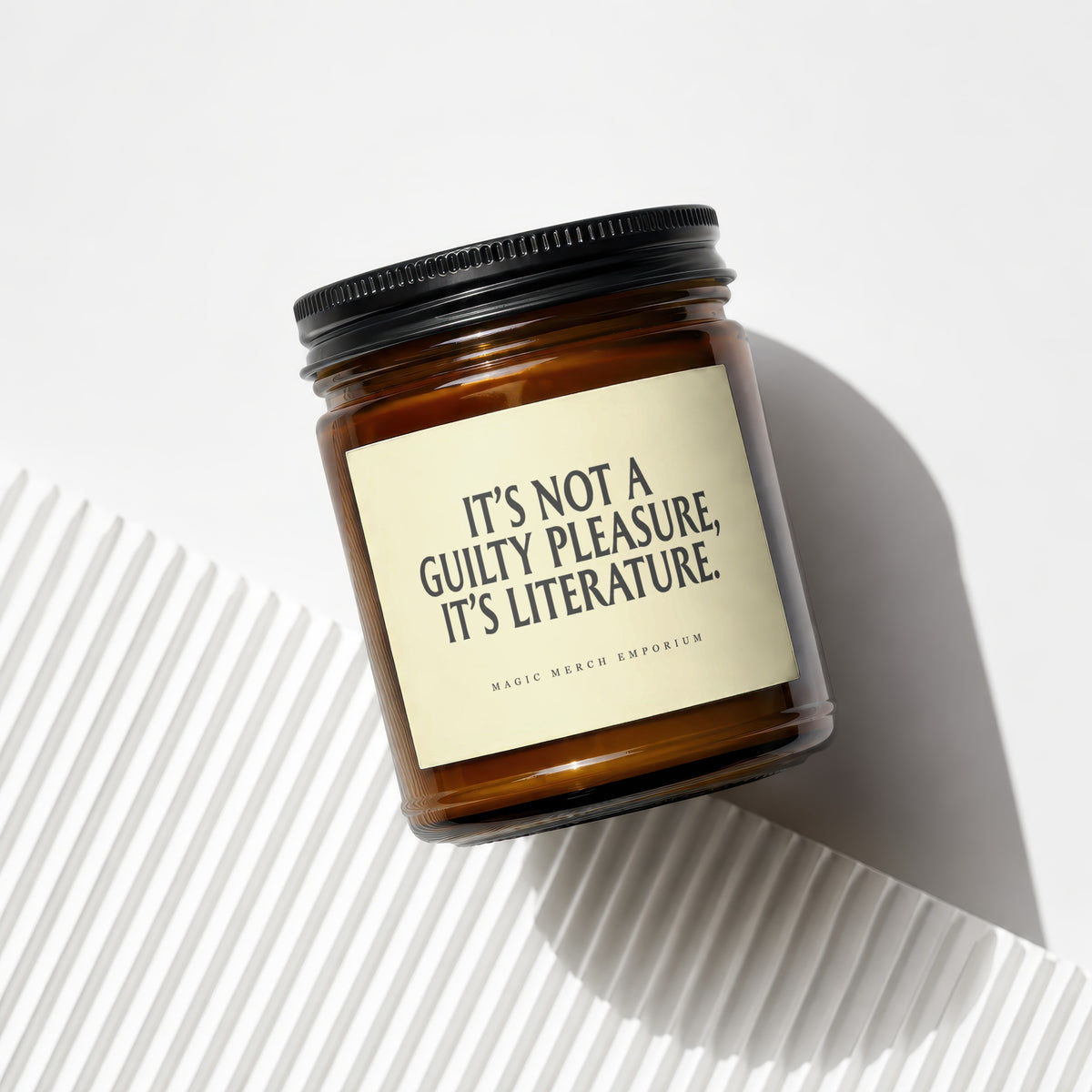 Amber glass candle with cream label reading "It's Not a Guilty Pleasure, It's Literature."