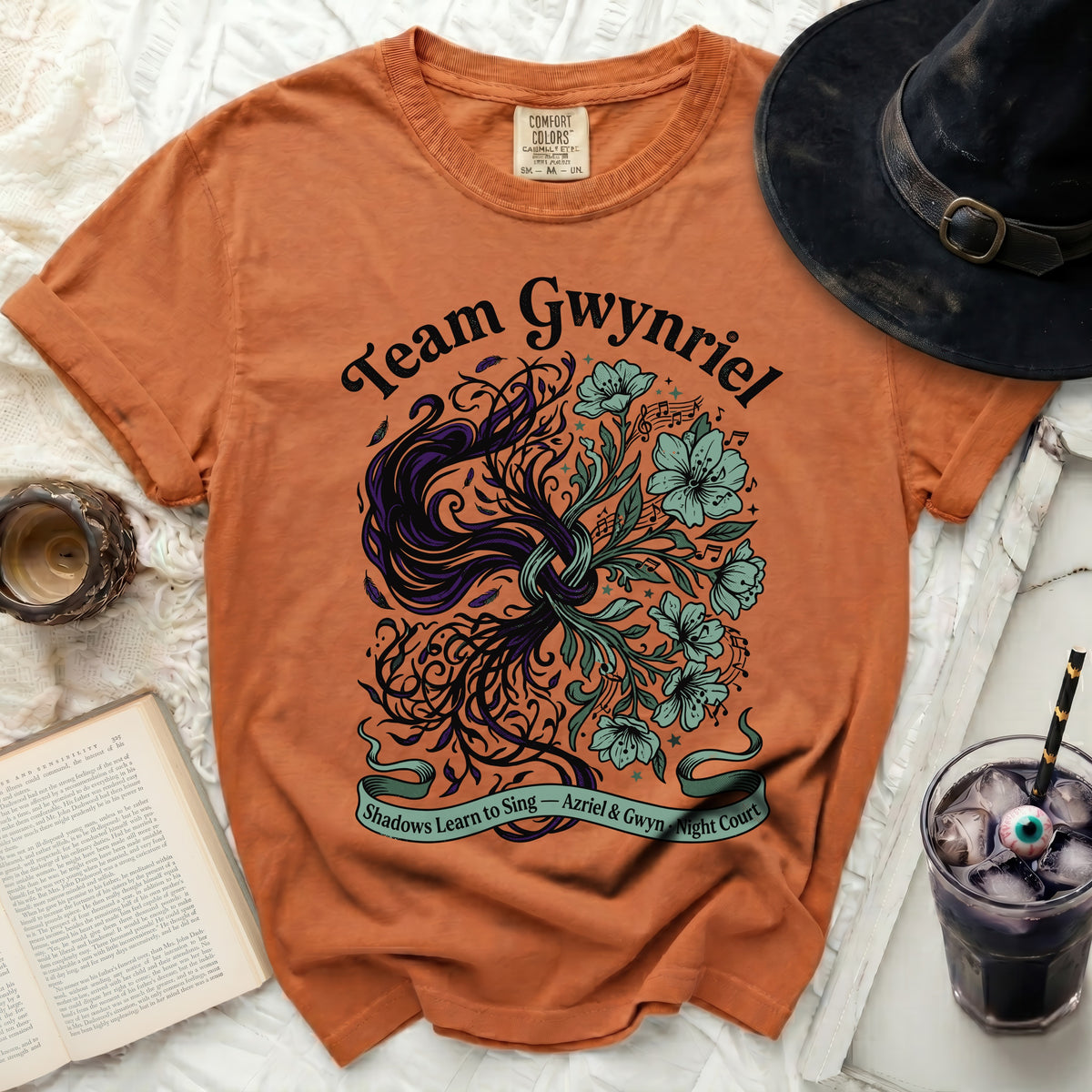 Orange t-shirt with "Team Gwynriel" and fantasy illustration of flora.